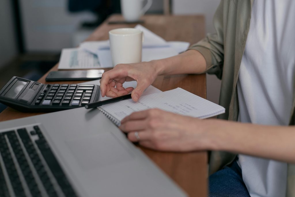 woman using a calculator to create a budget
